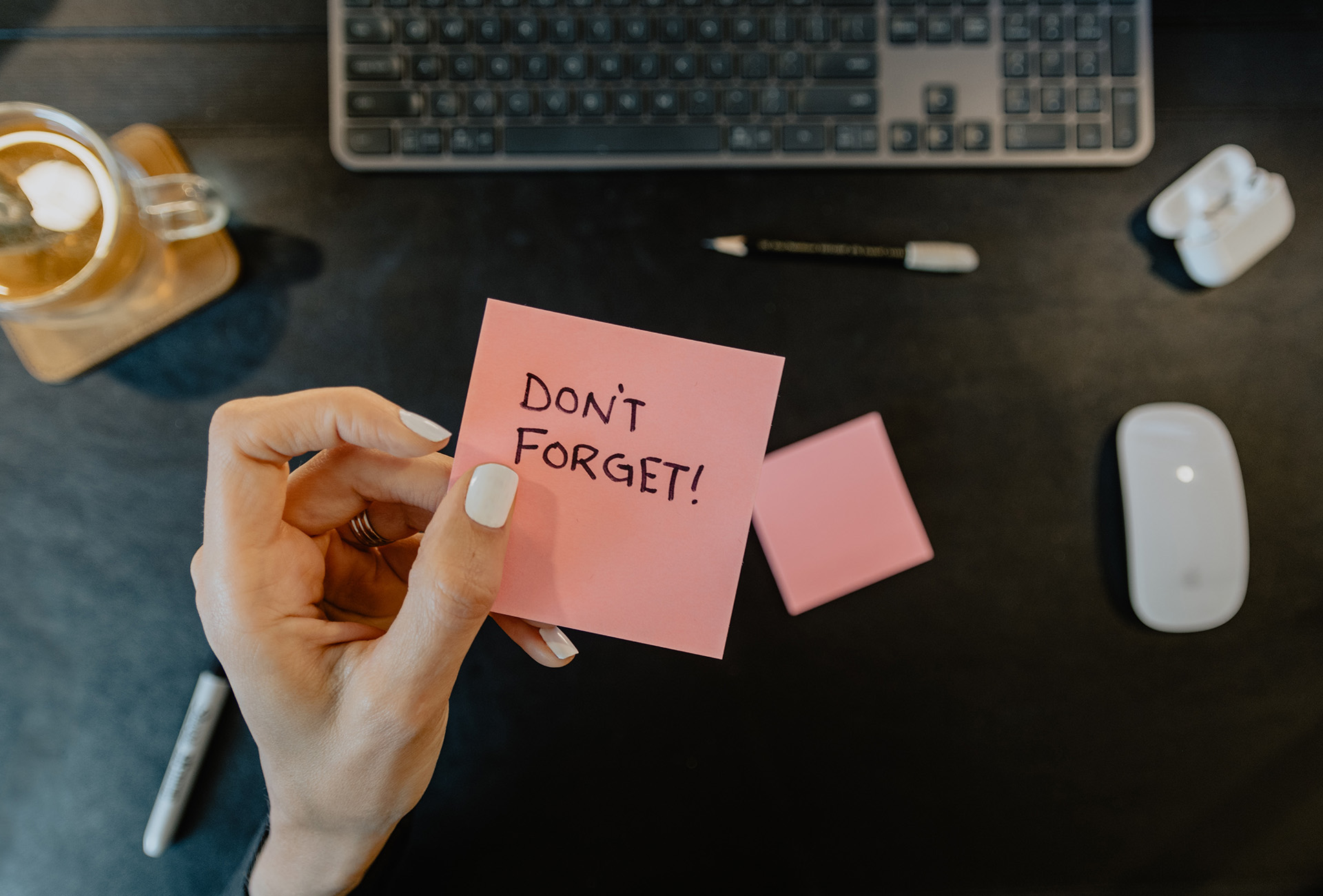 Photograph of a person holding a note that says: “Don’t forget!”